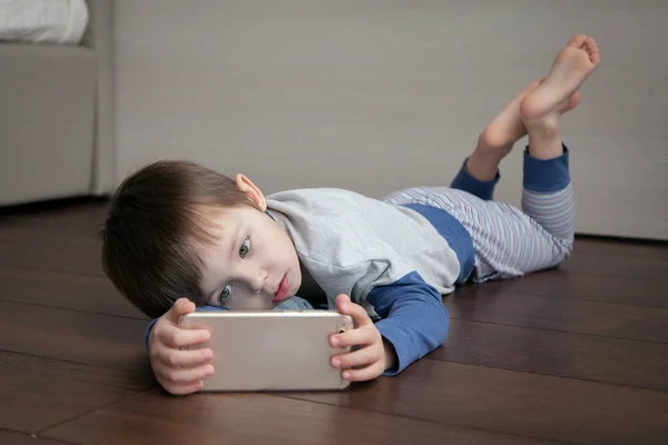 Enfant Couché Sur Sol Regarde Quelque Chose Intéressant Dans Gadget — Photo