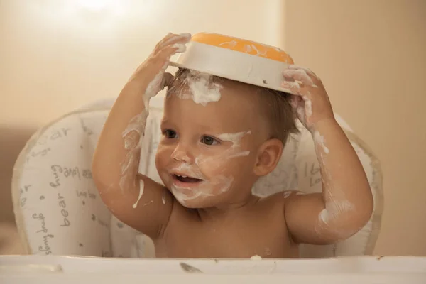Düşkünlük gıda ve mutlu bir sandalyede oturan küçük bir çocuk.
