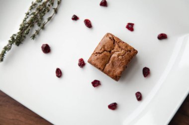 Çilek ve Yeşiller ile dekore edilmiş bir beyaz tabakta cupcake.