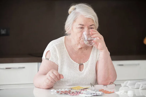 Abuela Sienta Mesa Bebe Agua Vaso Tabletas Sobre Mesa — Foto de Stock