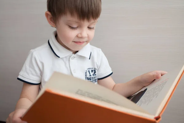 Милый Ребенок Читает Книгу Мальчик Интересом Смотрит Книгу — стоковое фото