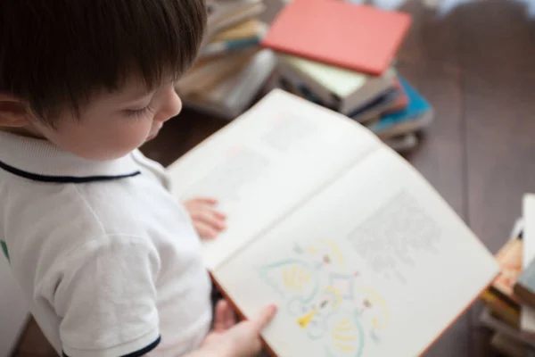 Симпатичный Ребенок Сидит Читает Большую Книгу — стоковое фото