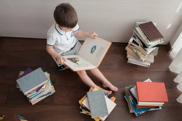 Rapaz Senta Nos Livros Torno Dele Estão Muitos Livros Coloridos — Fotografia de Stock