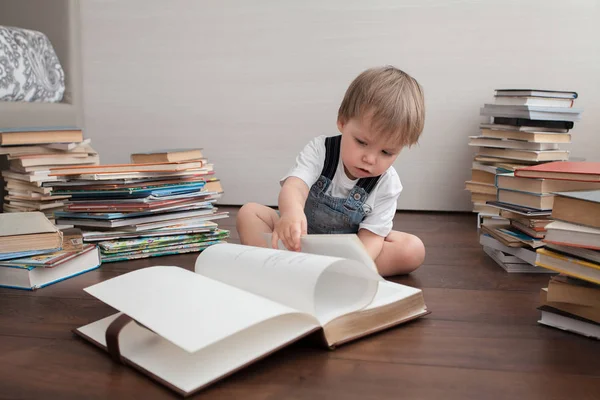 一个可爱的婴儿坐在地板上 看着一本大书 — 图库照片