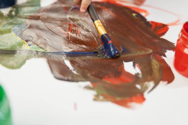 Beyaz çarşaf ve eylem çizmek için fırça çok renkli guaş.