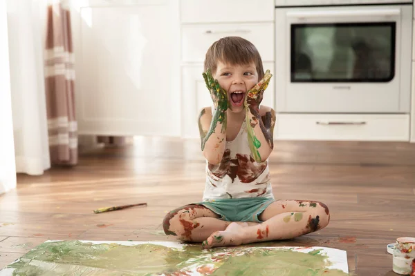 Hoş çocuk boyalar ve elleri kağıt üzerinde ve kendini çizer.