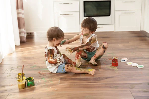 Dois Meninos Dois Irmãos Brincando Pintar Outro Sentado Chão — Fotografia de Stock