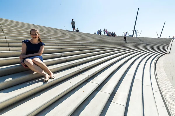 View of a girl sitting on the stairs at the Landungsbruecken in Hamburg, Germany — Stock Photo, Image