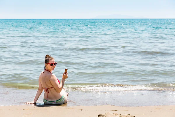 Chica con un helado en la playa del mar Tirreno en la región italiana Toscana —  Fotos de Stock