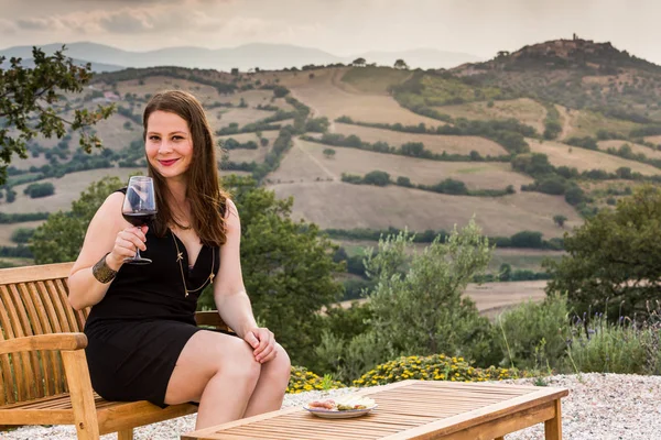 Ragazza con un bicchiere di vino al tramonto in Toscana — Foto Stock