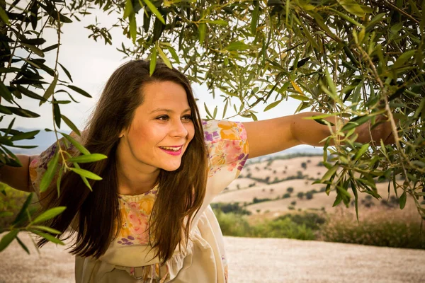 Bir kız eski zeytin ağacı altında ayakta görünümünü — Stok fotoğraf