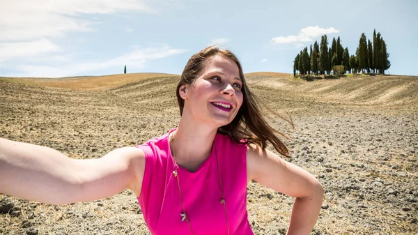 Ragazza in piedi nei campi toscani in estate — Foto Stock