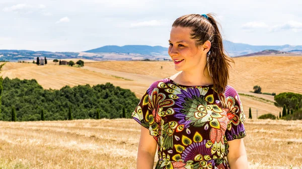 Девушка, стоящая на полях Тосканы летом — стоковое фото