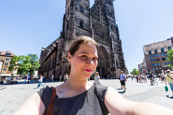 Lány vesz selfie elöl a Church of Our Lady — Stock Fotó