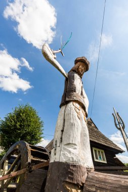 El yapımı ahşap heykel Podbiel Slovakya'da küçük köyde görünümünü