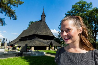 Kadının önünde antik tarihi kilise Dreveny Goticky Kostol, Tvrdosin