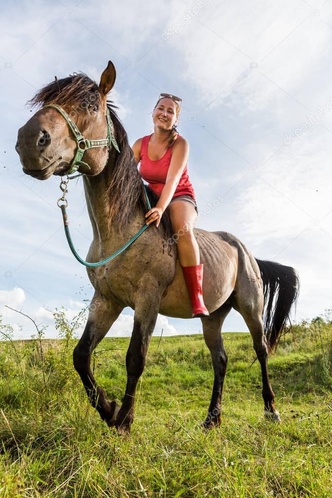 Girl sitting on a horse on a field in Slovakian region Orava