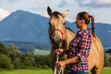 Slovakya'da bir at ile bir mavi ve kırmızı eşlenen gömlek ile kız