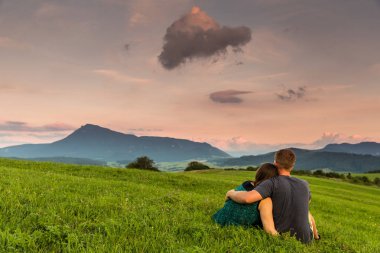 Slovakya bir çayır üzerinde gün batımını izlemek Çift
