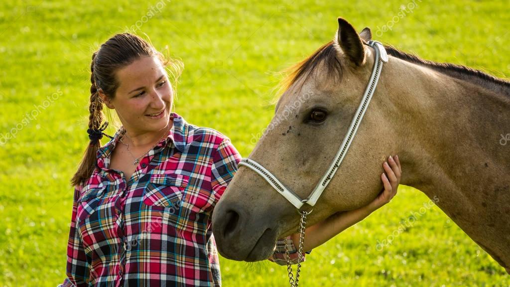 Mädchen mit blau-rot kartiertem Hemd mit Pferd in der Slowakei