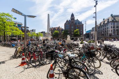Damrak Caddesi ve Amsterdam, Hollanda'nın eski şehir bölümü birçok bisiklet görünümünü binaların dış görünümü