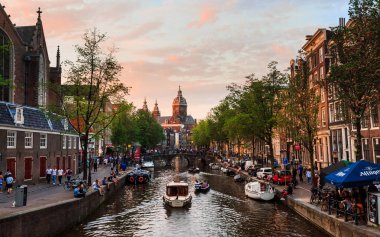 Dış görünümü Oude Kerk kilise ve canal adlı güzel gün batımı, Amsterdam, Hollanda