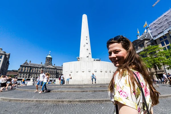 Nézd, egy lány, a Dam tér és a Nationaal emlékmű, Amszterdam, Hollandia — Stock Fotó