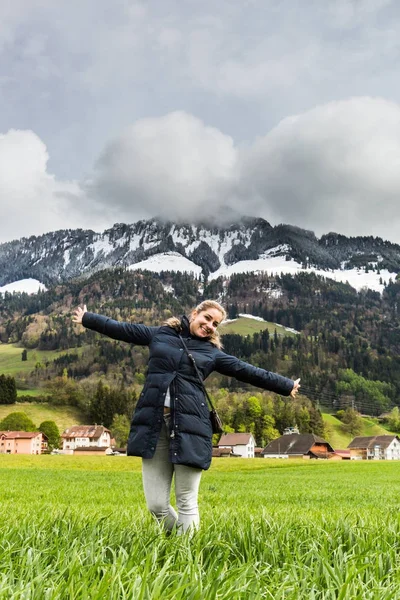 Flicka på en äng framför byn Gruyères i Schweiz — Stockfoto