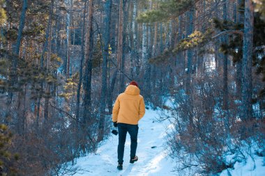 Ormanda sarı ceketli bir fotoğrafçı.