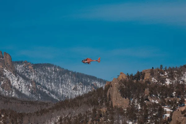 Dağların üzerinden uçan bir turist helikopteri.