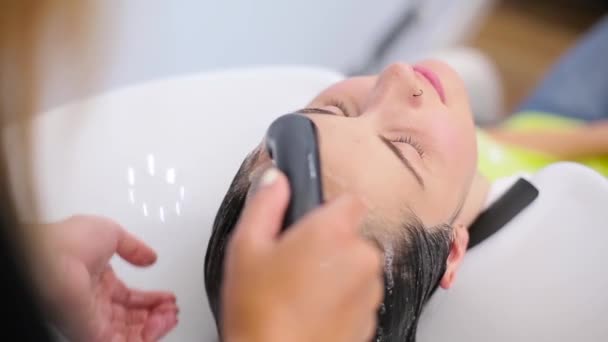 Девушка мыла волосы в парикмахерской — стоковое видео