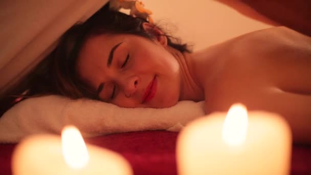 Massaggio alla schiena per una ragazza con candele — Video Stock