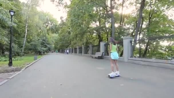 Девушка едет в парк на giroskutere — стоковое видео