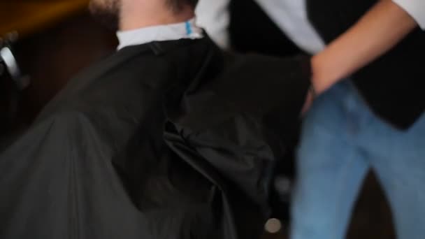 Мужчина, готовый к стрижке в парикмахерской — стоковое видео