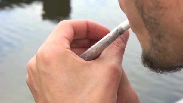 Чоловік запалює цигарку на вулиці — стокове відео