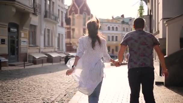 Pareja corre por el casco antiguo — Vídeo de stock