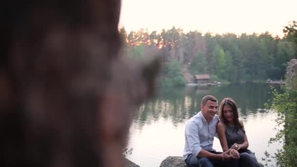 森の川の土手に座っているカップル — ストック動画