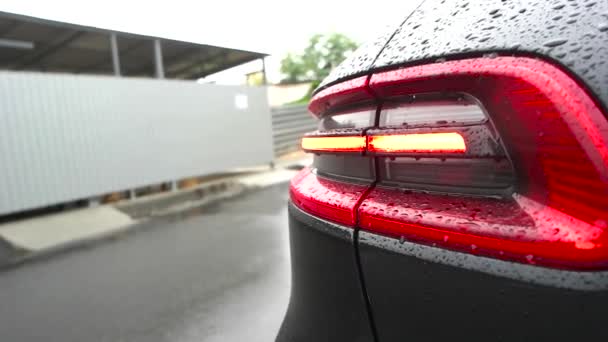 Faro del coche parpadeando bajo la lluvia — Vídeo de stock