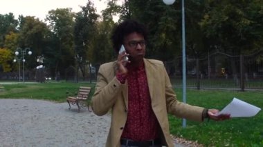 telefonu konuşurken ve belgeleri sokakta arayan adam