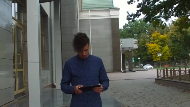 Le gars regarde la tablette dans la rue — Video