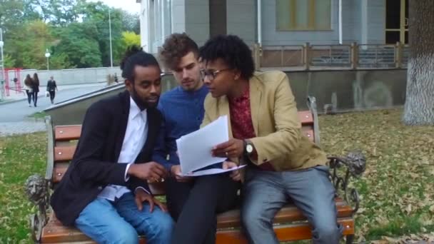 Les gars discutent des papiers dans la rue — Video