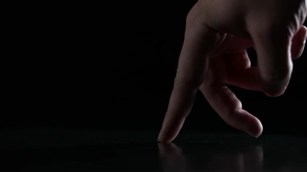 Siyah bir zemin üzerine yürüyen parmak — Stok video