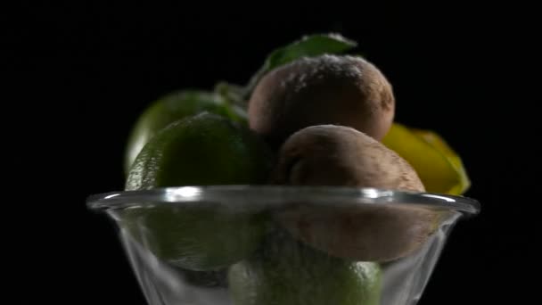 Tropische vruchten draaien op een oppervlak zwarte achtergrond — Stockvideo