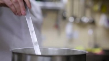 Aşçı gıda tavada kıpırdanırken.
