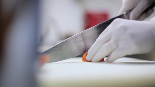 Chef corta el tomate en guantes — Vídeos de Stock