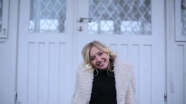 Mädchen lächelt, während sie auf der Veranda sitzt — Stockvideo