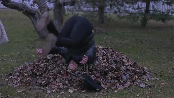 Мужчина и девушка прыгают в листьях — стоковое видео