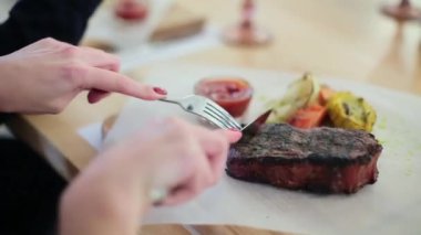 Kız bir lokantada biftek keser