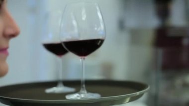Kız garson bardak şarap getirir