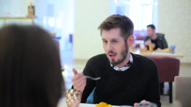 Hombre comiendo en un restaurante y hablando con una chica — Vídeos de Stock